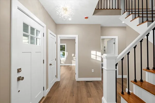 a view of a hallway with wooden floor and staircase