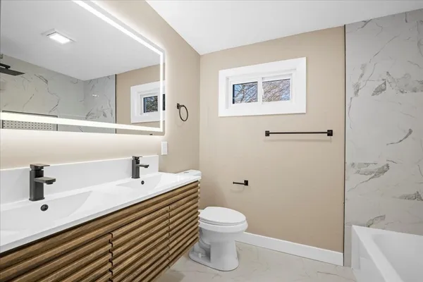 a bathroom with a sink a toilet and shower