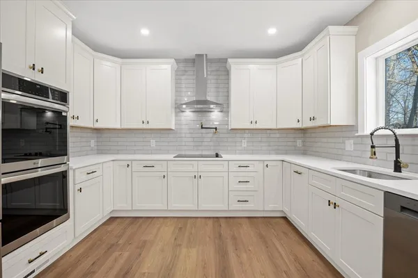 a kitchen with granite countertop white cabinets stainless steel appliances and sink