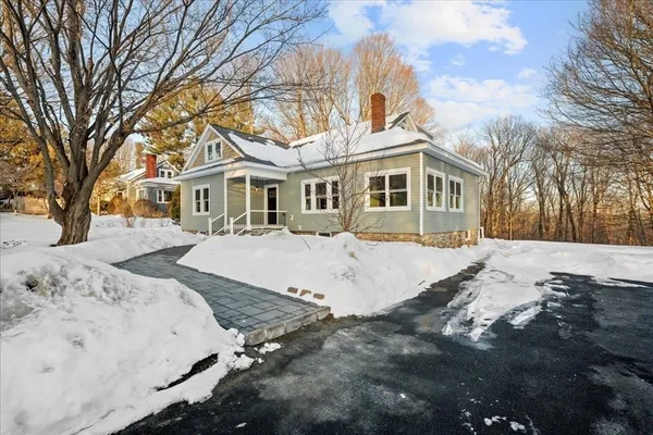 a front view of a house with a yard covered in snow