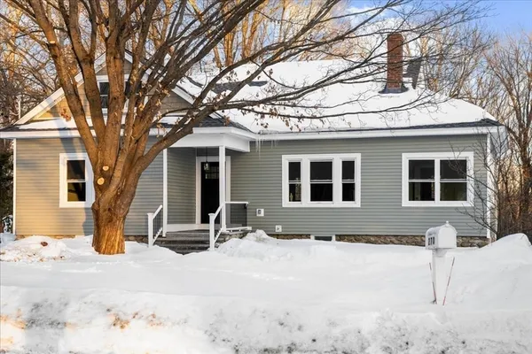 a front view of a house with a yard covered in snow