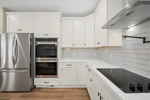a kitchen with white cabinets and stainless steel appliances