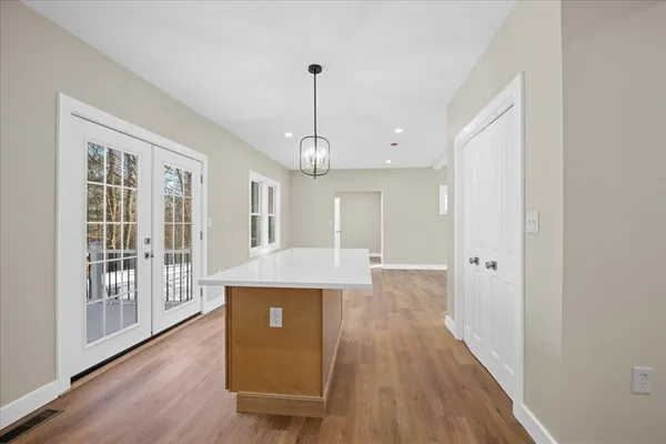 a view of a kitchen with wooden floor and a window