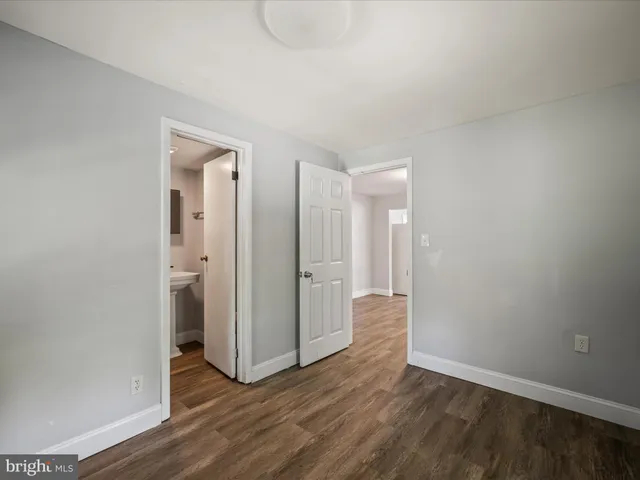 an empty room with wooden floor & bathroom