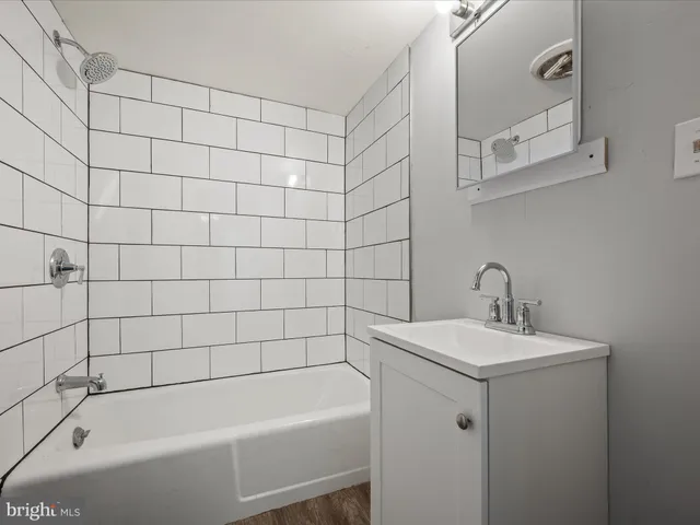 a white bath tub sitting next to a white sink and vanity