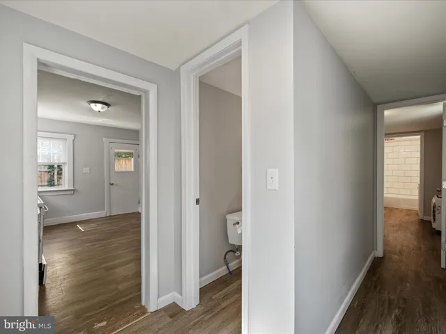 a view of a hallway with wooden floor and a livingroom