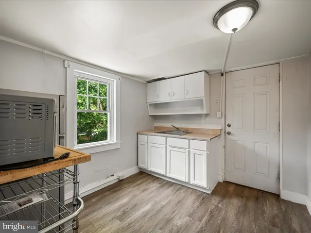 a kitchen with stainless steel appliances granite countertop a stove a sink and a refrigerator with wooden floors