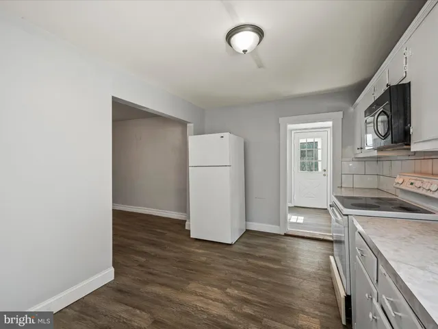 an empty room with wooden floor and cabinets