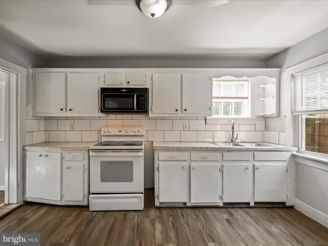 a kitchen with stainless steel appliances white cabinets a sink and a stove