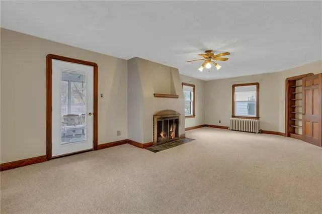 a view of a livingroom with a fireplace and window