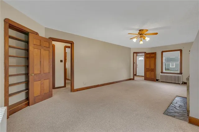 a view of an empty room with window and cabinet