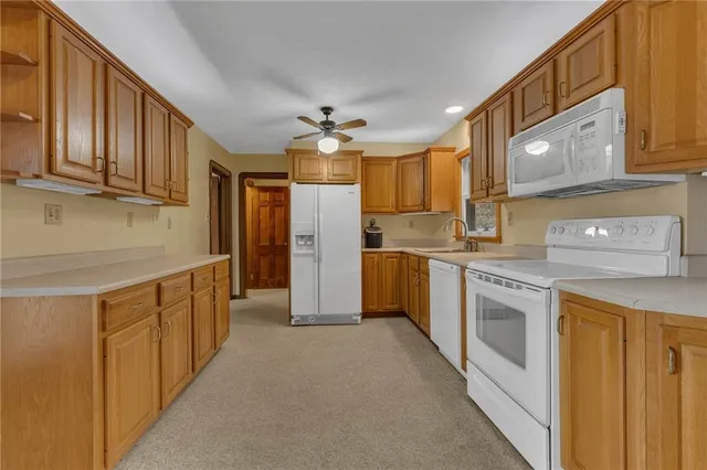a kitchen with stainless steel appliances granite countertop a refrigerator a sink and a stove