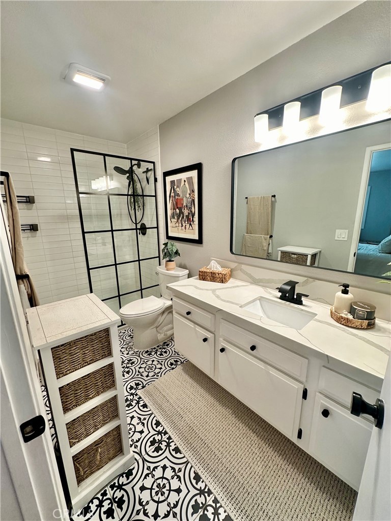 1045 East 3rd Street, Unit 4 Long Beach, CA 90802 - Photo 13 of 20 a en suite bathroom with double vanity sink a mirror and a shower