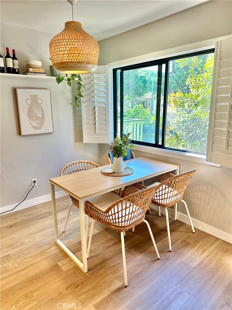 1045 East 3rd Street, Unit 4 Long Beach, CA 90802 - Photo 9 of 20 a dining room with furniture a chandelier and wooden floor