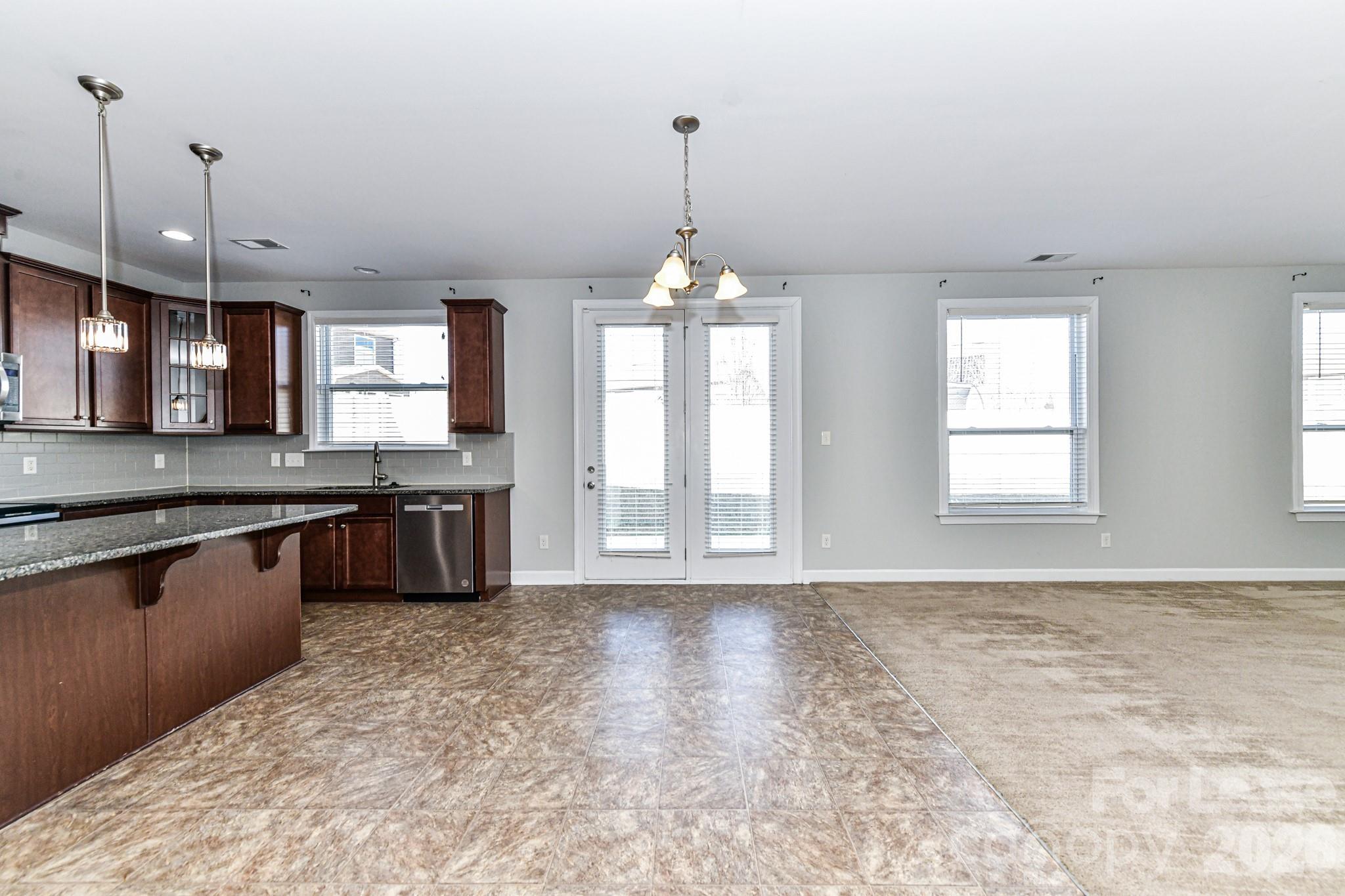 4316 Hubbard Road Charlotte, NC 28269 - Photo 17 of 46 a large kitchen with kitchen island granite countertop a sink window and stainless steel appliances