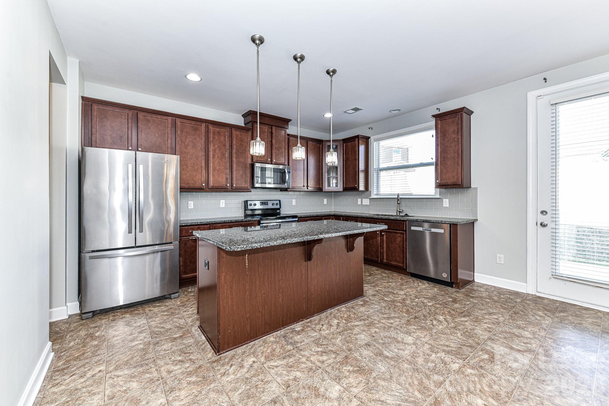 4316 Hubbard Road Charlotte, NC 28269 - Photo 18 of 46 a kitchen with stainless steel appliances granite countertop a refrigerator a sink dishwasher a stove with wooden cabinets