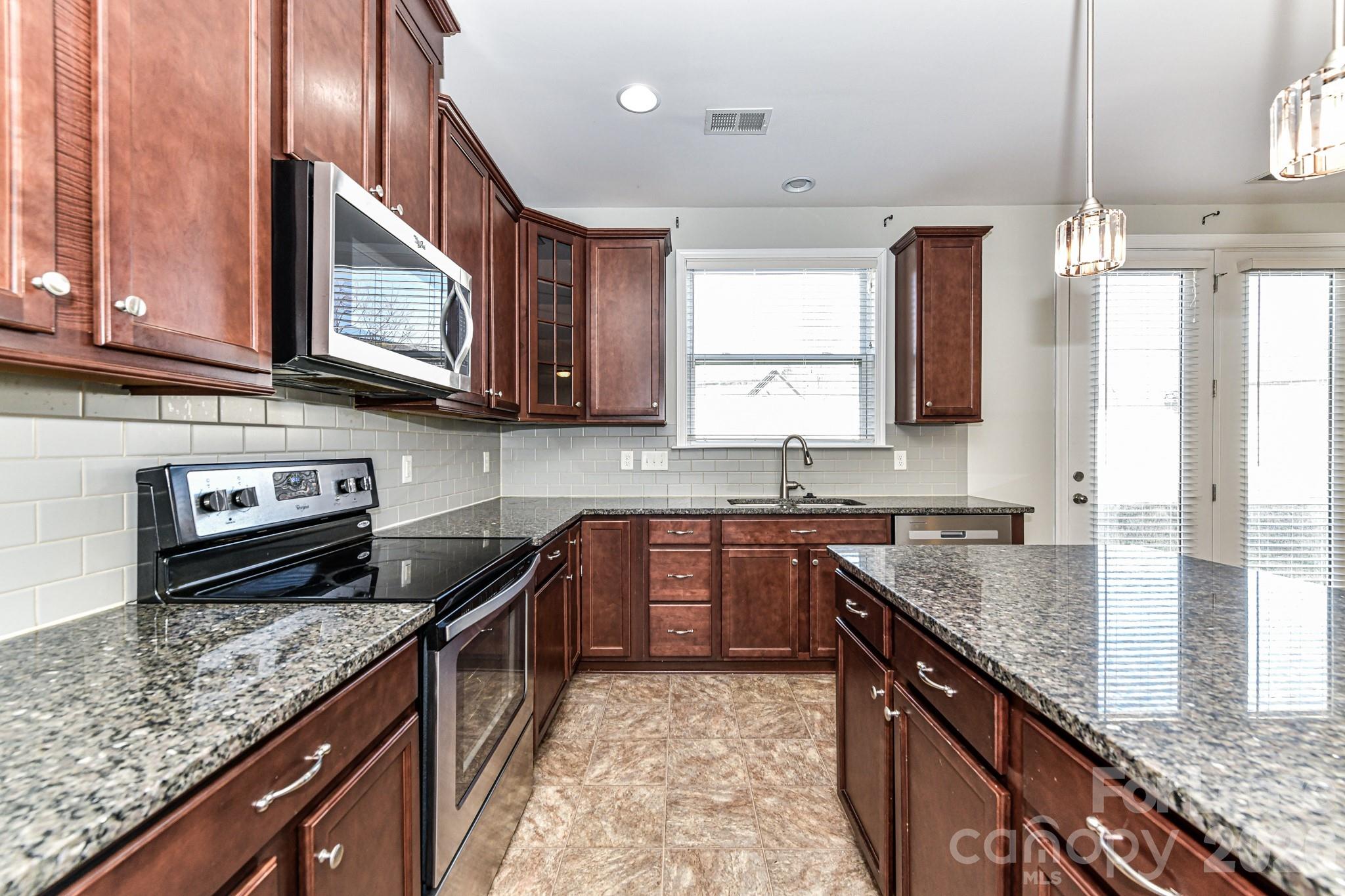4316 Hubbard Road Charlotte, NC 28269 - Photo 20 of 46 a kitchen with stainless steel appliances granite countertop a sink stove and microwave