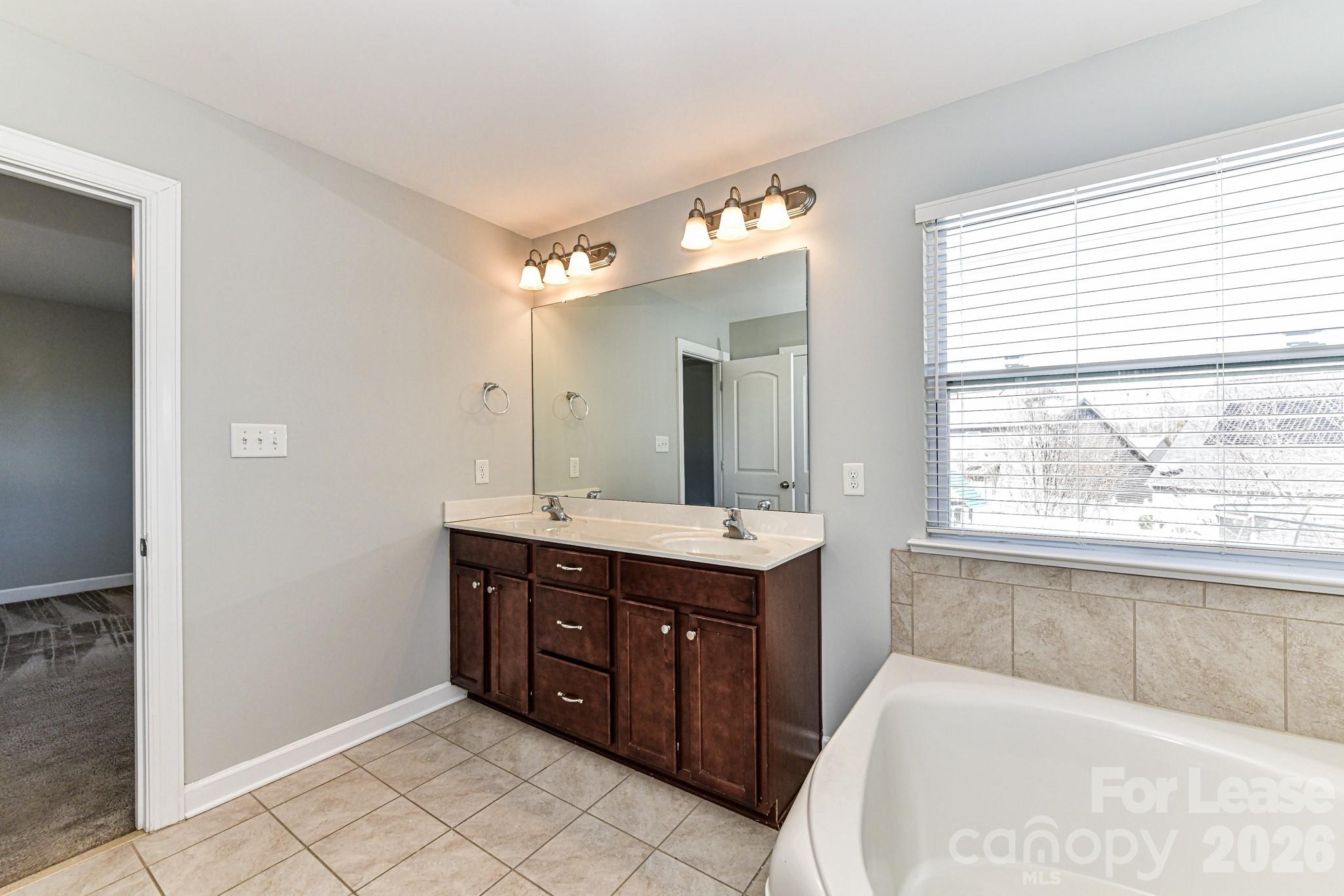 4316 Hubbard Road Charlotte, NC 28269 - Photo 29 of 46 a spacious bathroom with a tub sink and mirror