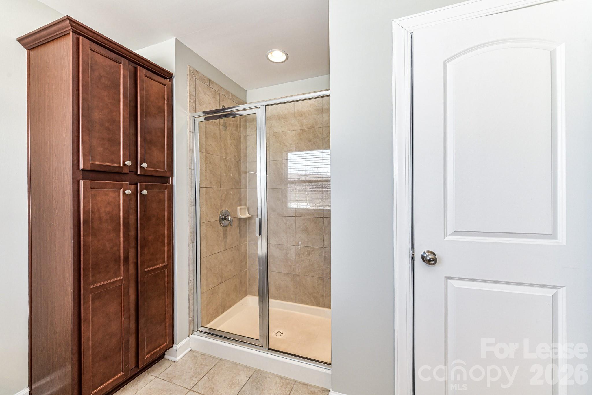 4316 Hubbard Road Charlotte, NC 28269 - Photo 30 of 46 a bathroom with a glass shower door