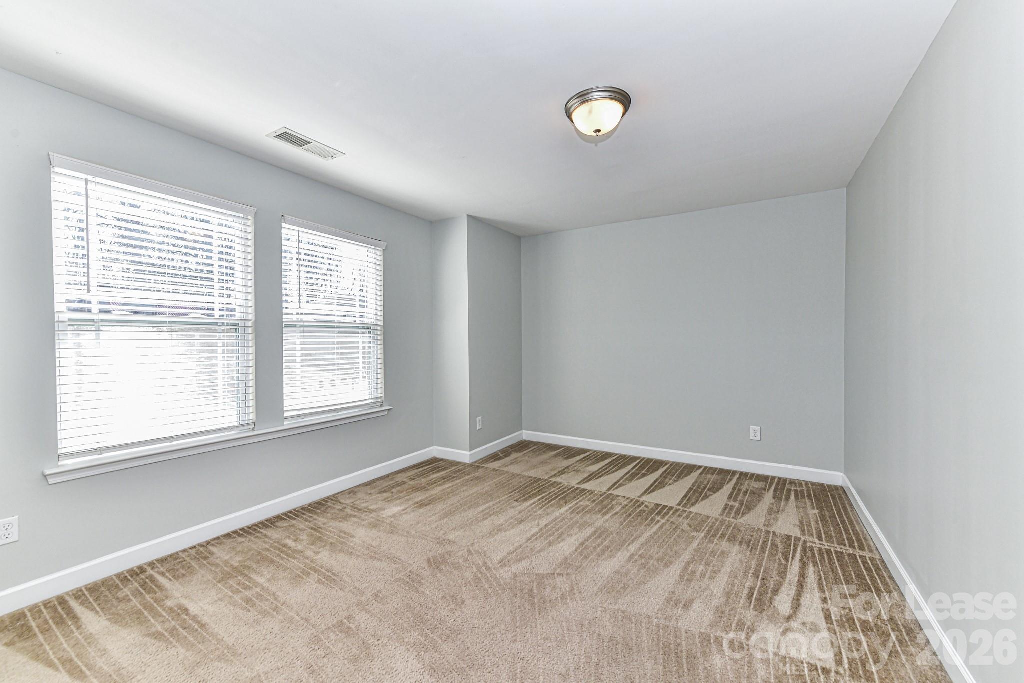 4316 Hubbard Road Charlotte, NC 28269 - Photo 37 of 46 an empty room with wooden floor and windows