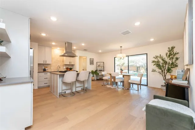 a living room with furniture kitchen view and a large window
