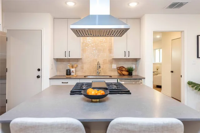 a kitchen with a refrigerator and a stove top oven