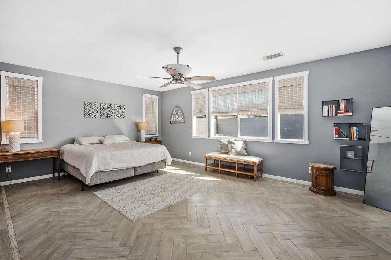 42724 Tango Court Indio, CA 92203 - Photo 14 of 27 a bedroom with a large bed and wooden floor