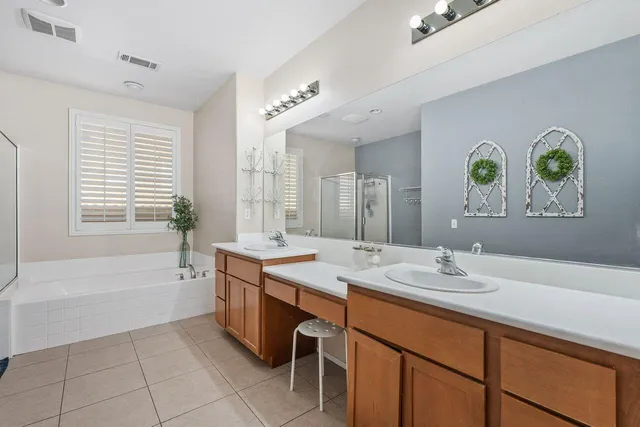 a spacious bathroom with a granite countertop sink a large mirror a bathtub and next to a window