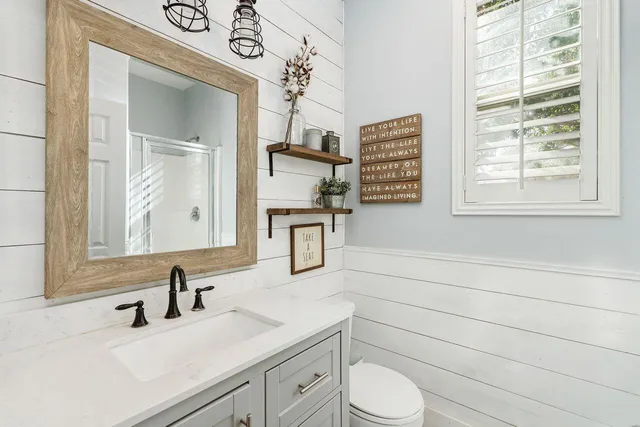 a bathroom with a sink a toilet and a mirror
