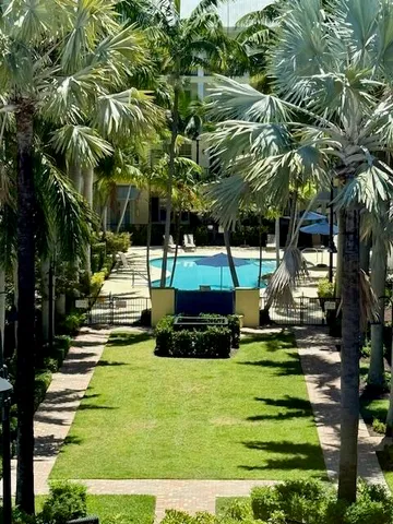 a front view of multi story residential apartment building with yard and green space