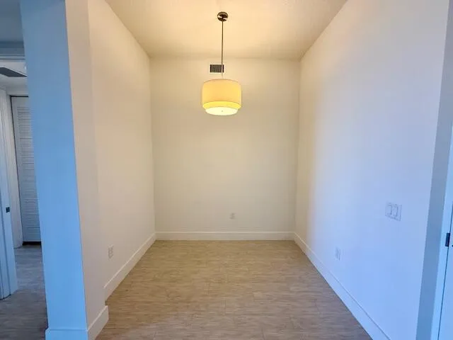 a view of a room with wooden floor and a window