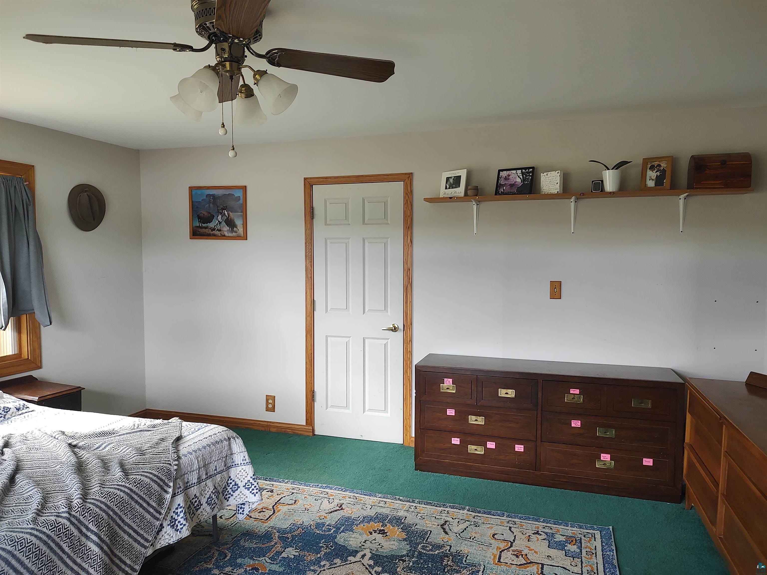 2585 Hautala Road Iron River, WI 54847 - Photo 18 of 28 Bright interior space featuring a ceiling fan with integrated lighting, a white panel door with wood trim, and a window with wood trim