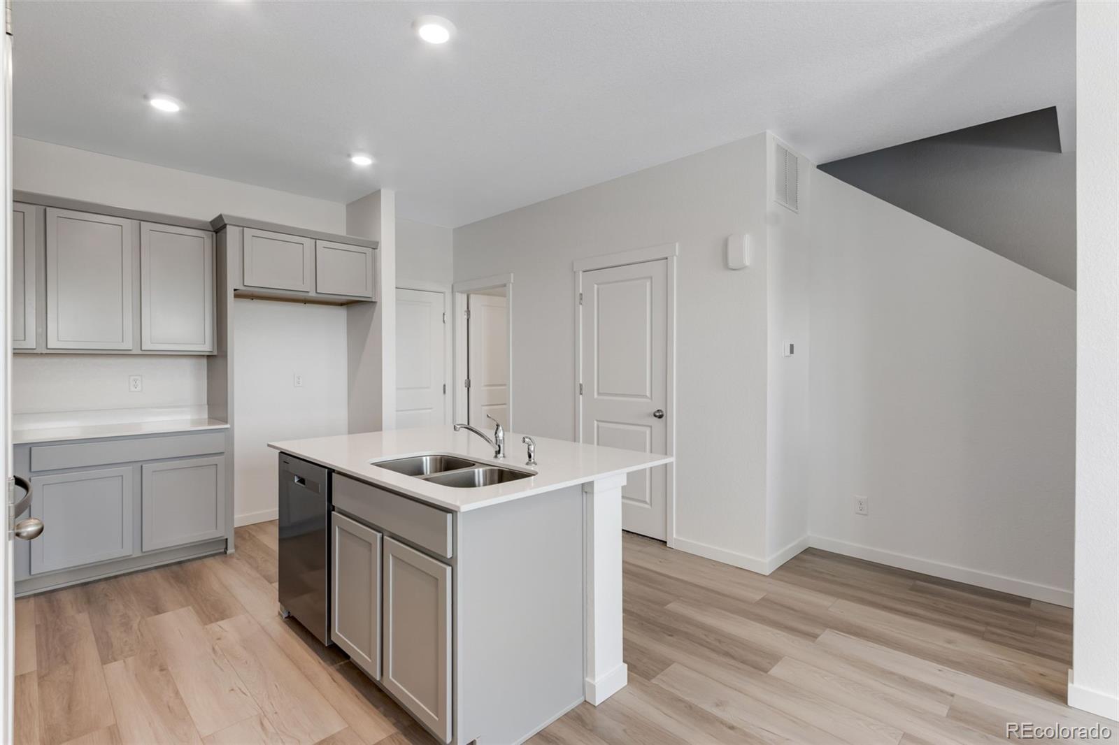 2360 Merlot Street Fort Lupton, CO 80621 - Photo 5 of 21 a kitchen that has a sink a stove and wooden floor