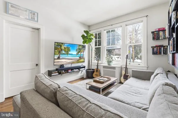 a living room with furniture a large window and flat screen tv