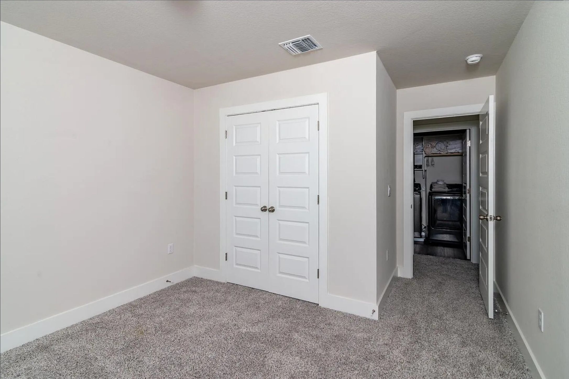 7501 Travertine Spring Drive Austin, TX 78744 - Photo 23 of 28 Neutral wall finishes complement the gray textured carpeting