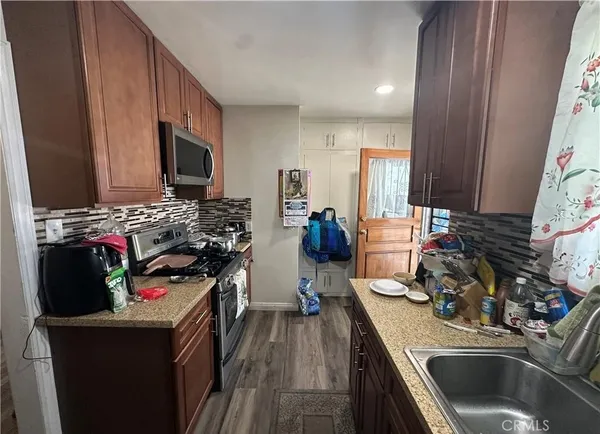 a kitchen with sink a microwave a stove and cabinets