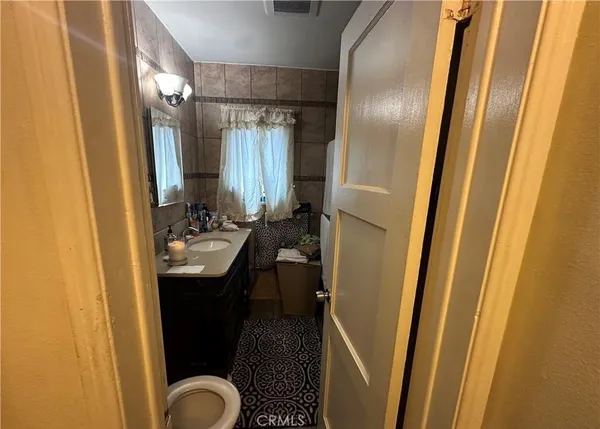 a bathroom with a sink a toilet a mirror and shower
