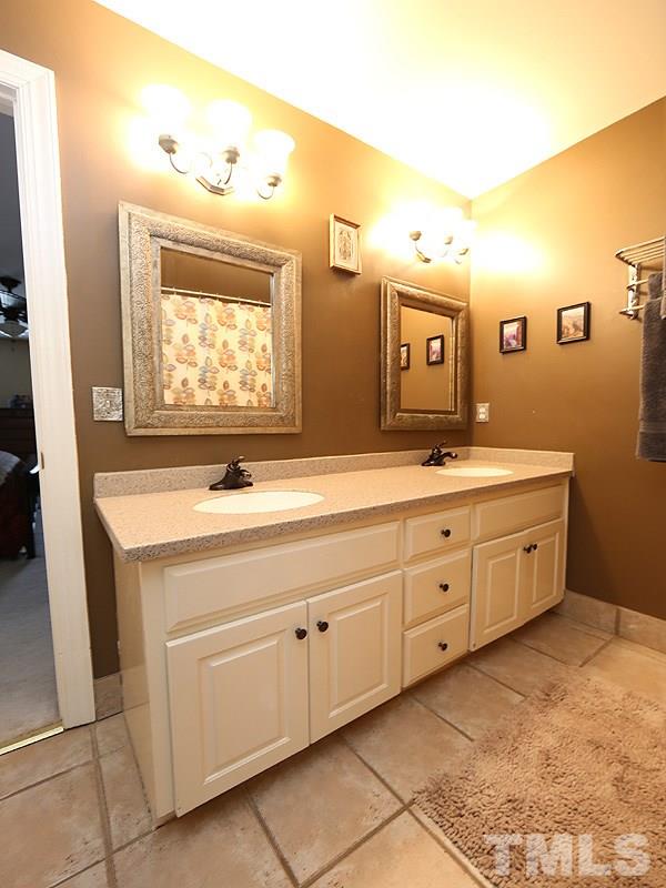 8208 Mourning Dove Road Raleigh, NC 27615 - Photo 13 of 25 a spacious bathroom with a double vanity sink a mirror and a