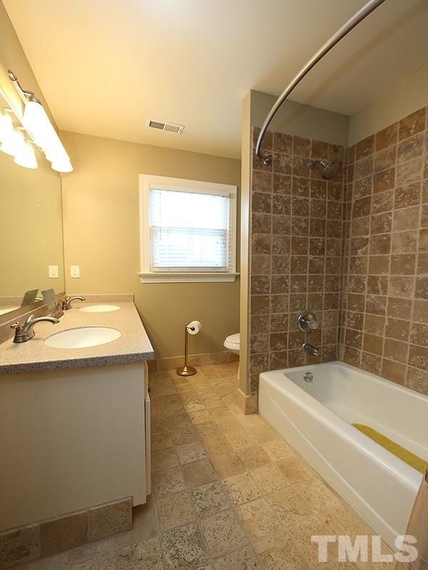 8208 Mourning Dove Road Raleigh, NC 27615 - Photo 17 of 25 a bathroom with a sink and mirror