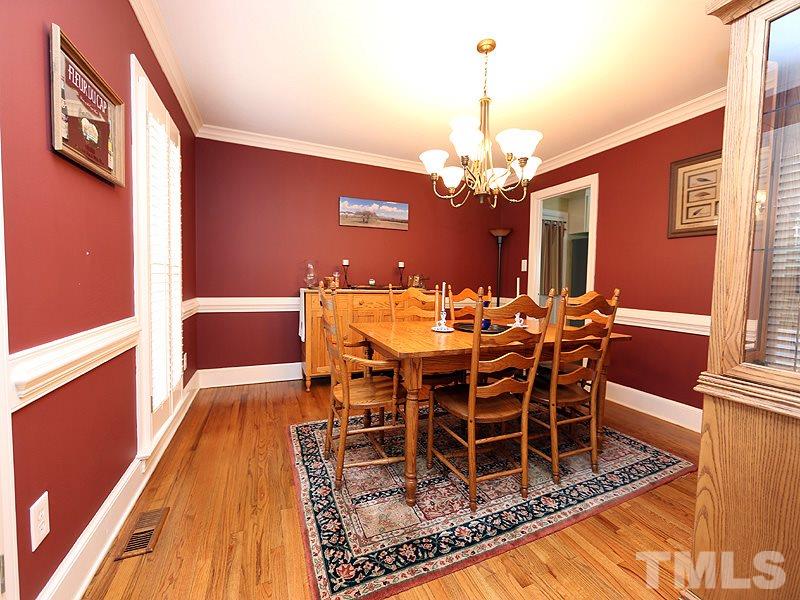 8208 Mourning Dove Road Raleigh, NC 27615 - Photo 4 of 25 a dining room with furniture a chandelier and wooden floor