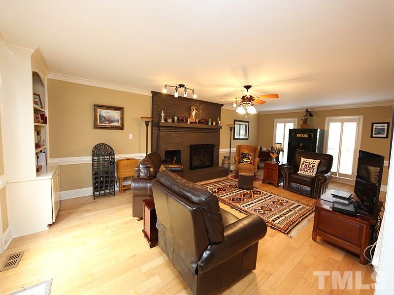 8208 Mourning Dove Road Raleigh, NC 27615 - Photo 5 of 25 a living room with furniture a fireplace and a flat screen tv
