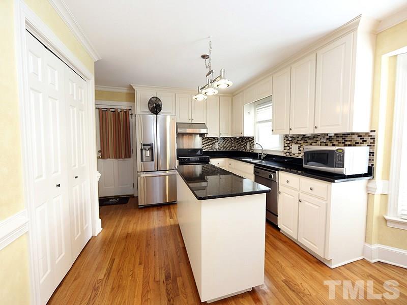 8208 Mourning Dove Road Raleigh, NC 27615 - Photo 8 of 25 a kitchen with a sink a stove a refrigerator and cabinets
