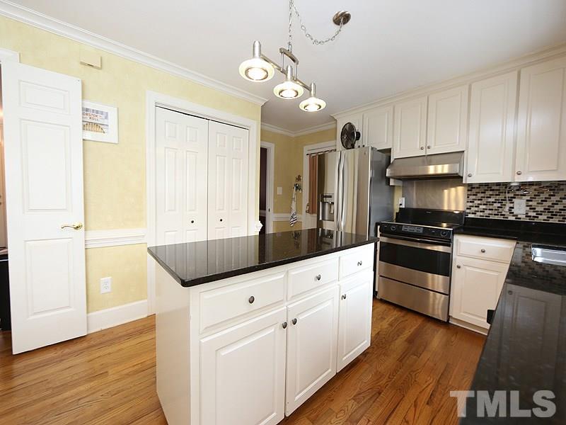8208 Mourning Dove Road Raleigh, NC 27615 - Photo 9 of 25 a kitchen with granite countertop white cabinets and black appliances