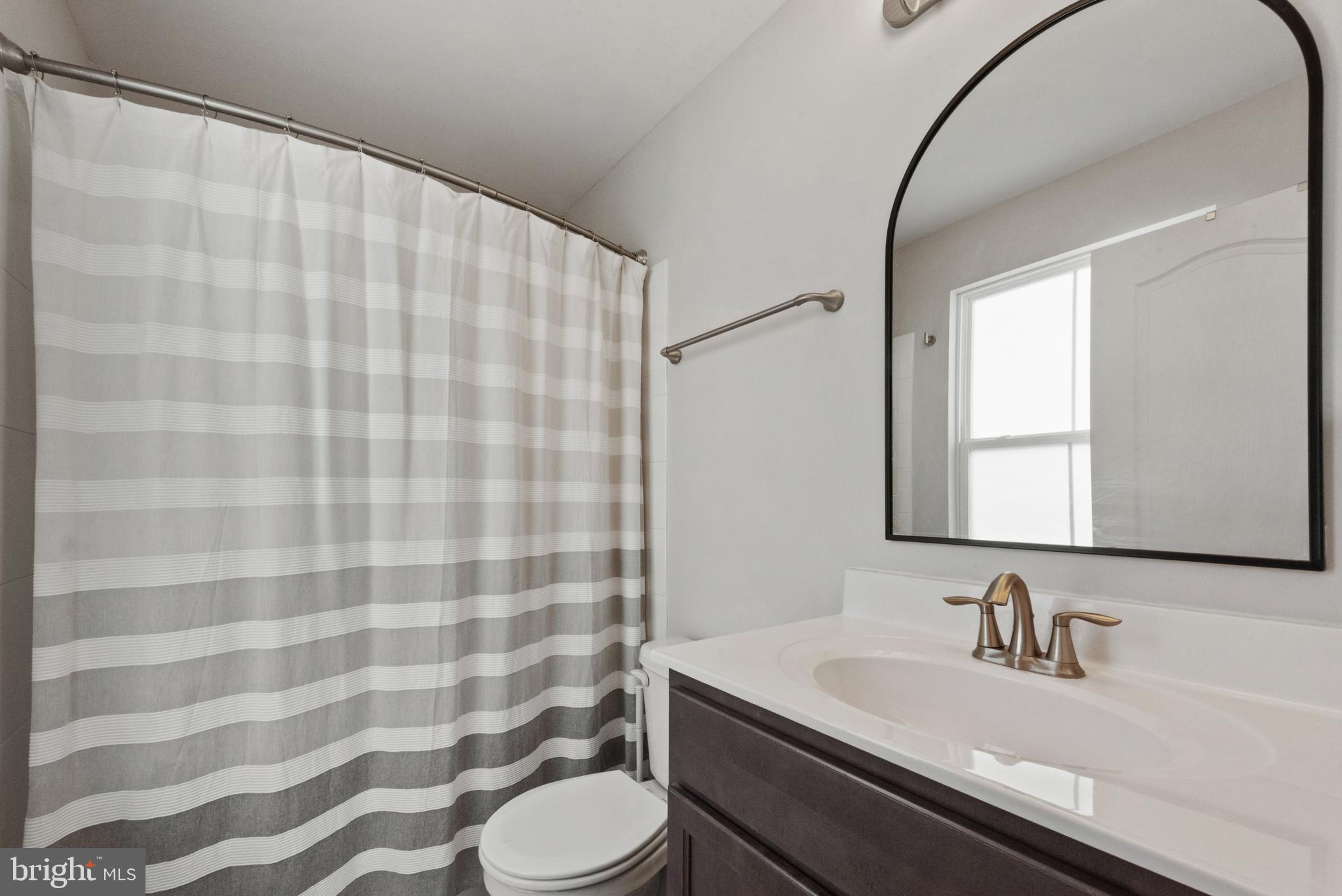 61 Grant Street Taneytown, MD 21787 - Photo 19 of 34 a bathroom with a granite countertop sink a toilet and a mirror