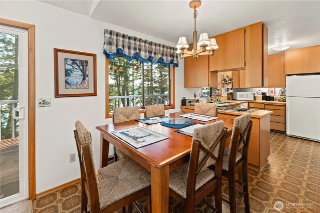 a dining room with furniture a chandelier and window