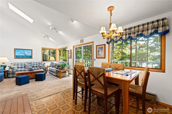 a dining room with furniture a chandelier and window