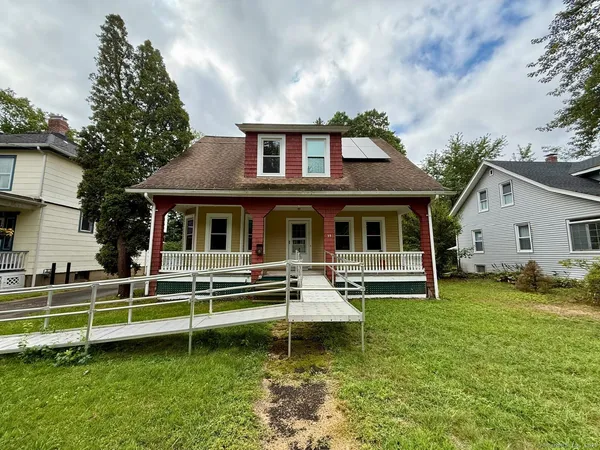 a front view of a house with a yard table and chairs