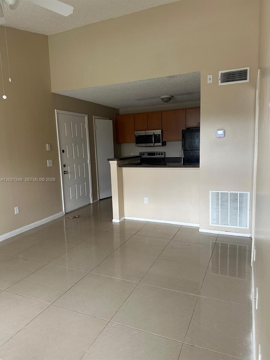 4481 West McNab Road, Unit 37 Pompano Beach, FL 33069 - Photo 14 of 20 a living room with a couch and a flat screen tv