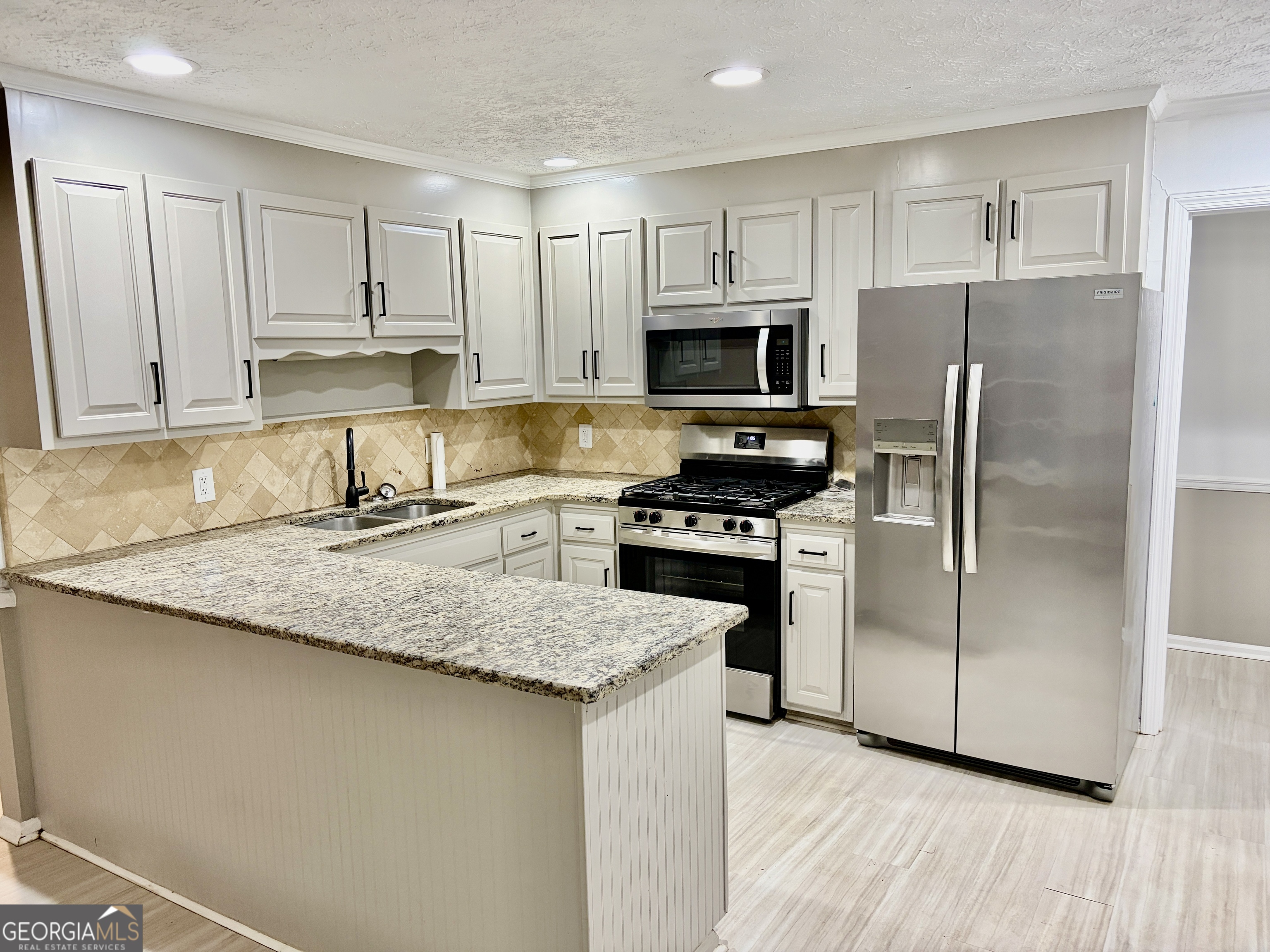 9 Argon Drive Northwest Rome, GA 30165 - Photo 8 of 14 a kitchen with granite countertop a refrigerator a sink a stove a microwave and wooden cabinets
