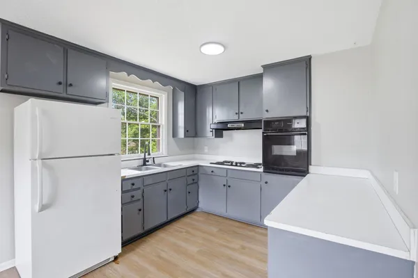 a kitchen with stainless steel appliances granite countertop a refrigerator sink and wooden cabinets